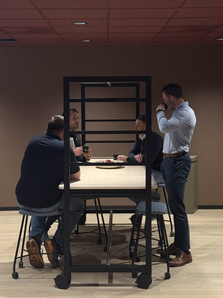 Ansatte hos Bravida samlet rundt møtebord i sosial sone i nye kontorlokaler i Bergen