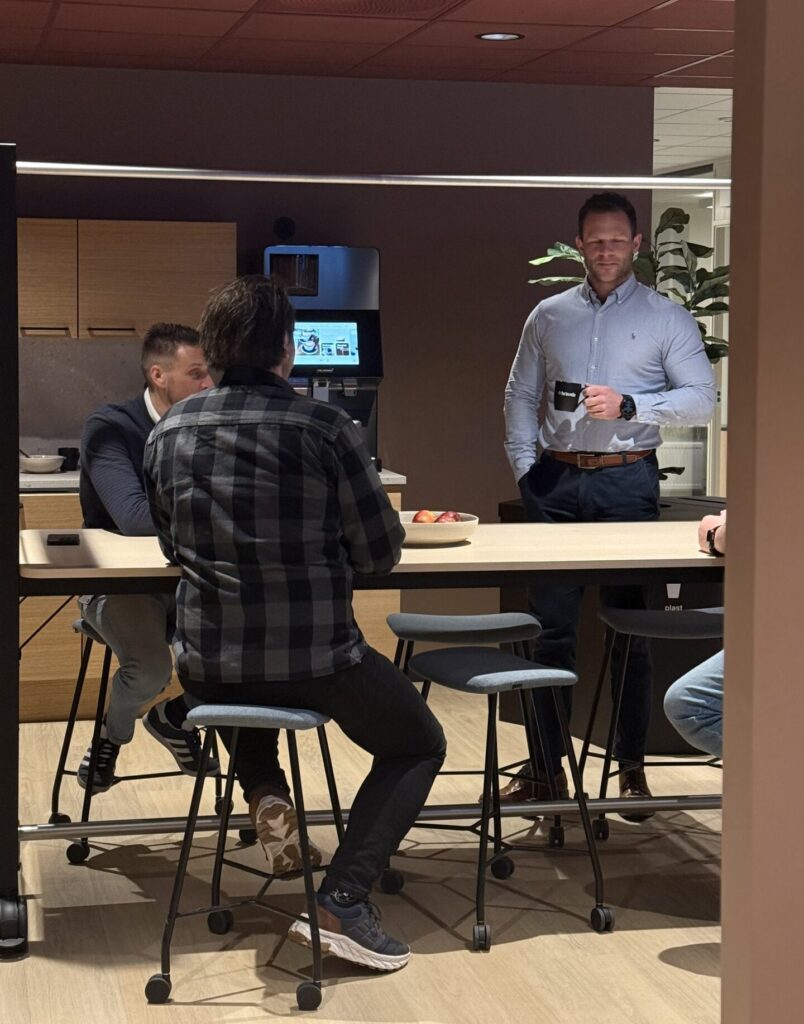 Ansatte hos Bravida samlet i sosial sone ved kaffemaskin i nye kontorlokaler i Bergen